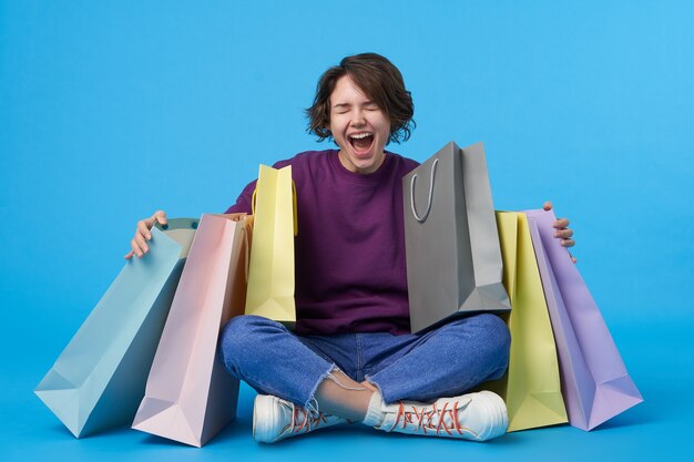 Young attractive dark haired woman with short haircut with a lot of shopping bags