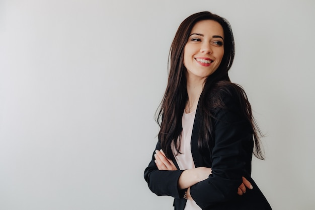 Young attractive emotional girl in business-style clothes on a plain white background in an office or audience