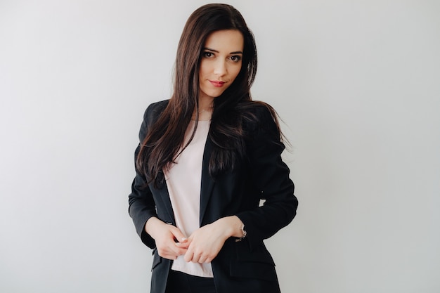 young attractive emotional girl in business-style clothes on a plain white surface in an office or audience