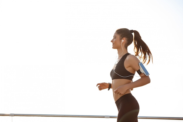 Free photo young attractive fitness girl jogging by the sea