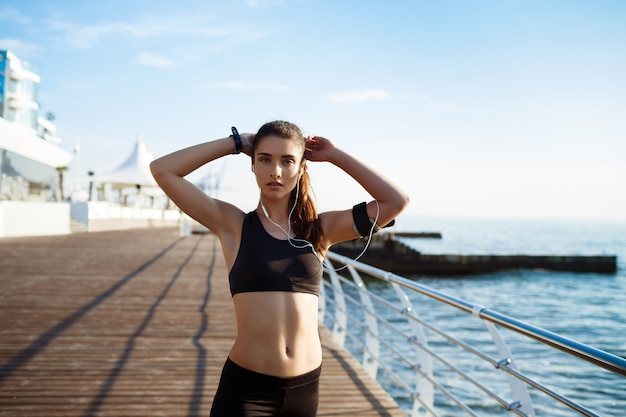  young attractive fitness girl with sea coast on wall