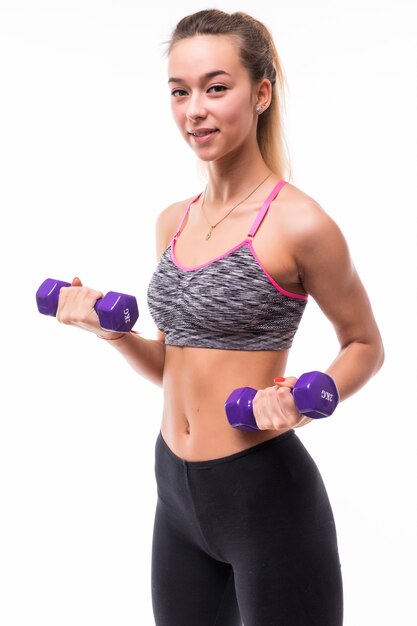 Young attractive fitness girl woman make different aerobics exercises with dumbbells on white dressed up in sportswear