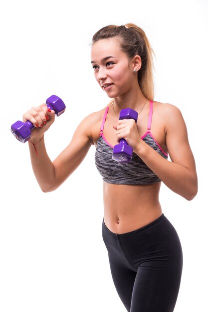 Young attractive fitness girl woman make different aerobics kick exercises with dumbbells on white dressed up in sportswear