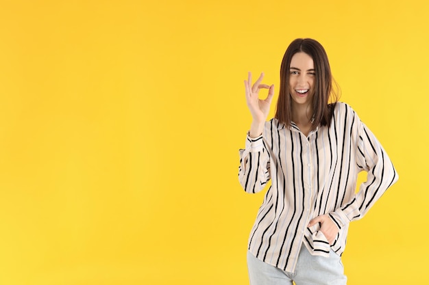 Young attractive girl in shirt on yellow background