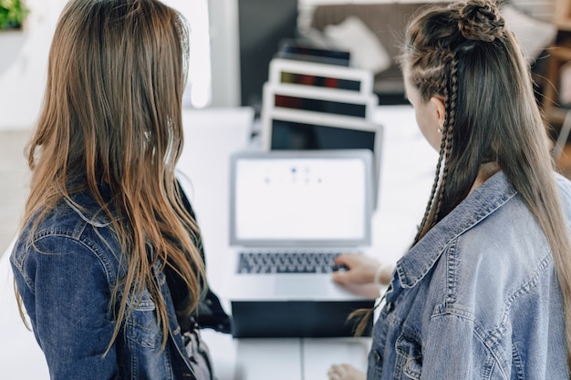 Young attractive girls in an electronics store use a laptop at an exhibition. concept of buying gadgets.