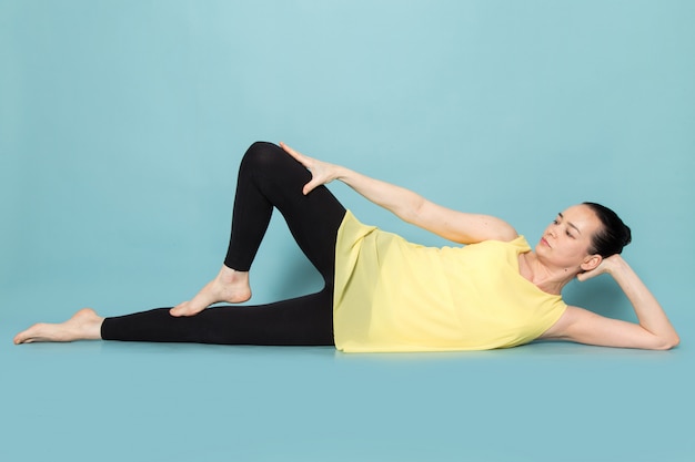 Young attractive lady in yellow shirt and black trousers posing