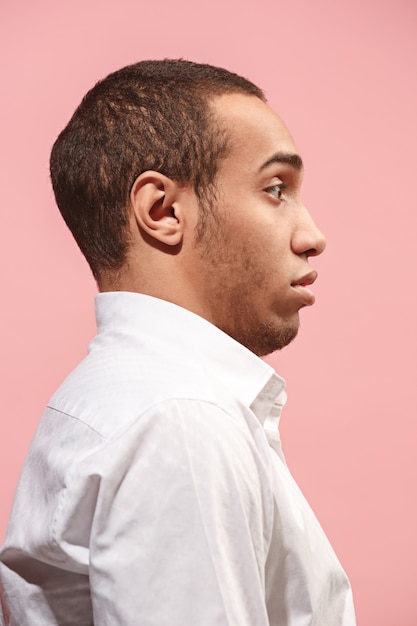 young attractive man looking suprised isolated on pink