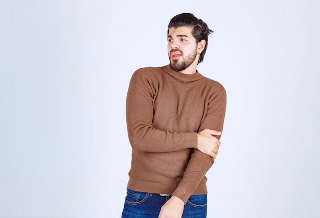 young attractive model standing over white wall.