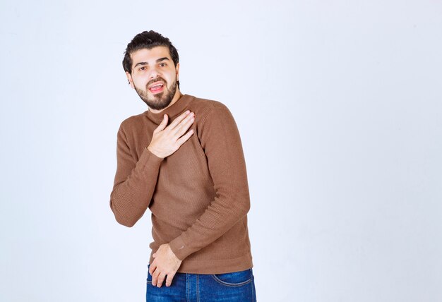 young attractive model standing over white wall.