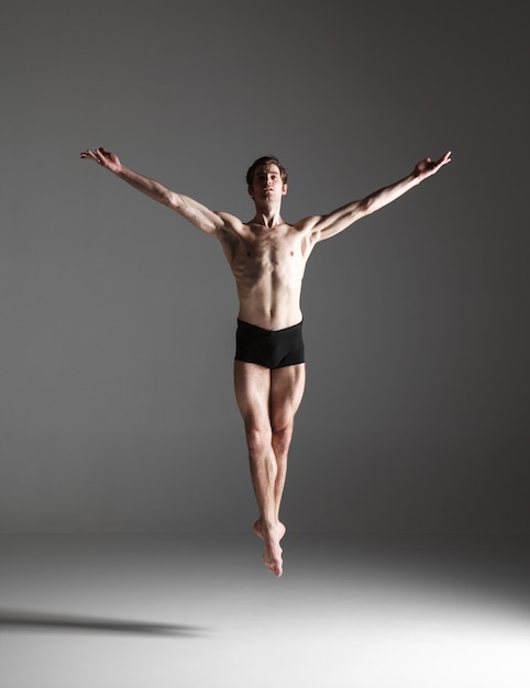 young attractive modern ballet dancer jumping on white