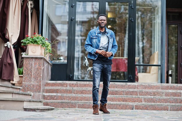젊은 매력적인 심각한 아프리카계 미국인 남자 모델 도시의 거리에 서 있는 청바지 재킷에 현대 잘생긴 남자