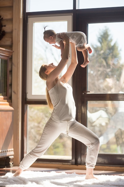 Free photo young attractive sporty mother doing exercises with her baby