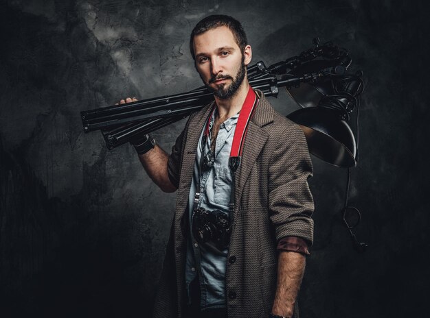 Young attractive student is carrying special lamp while posing for photographer.