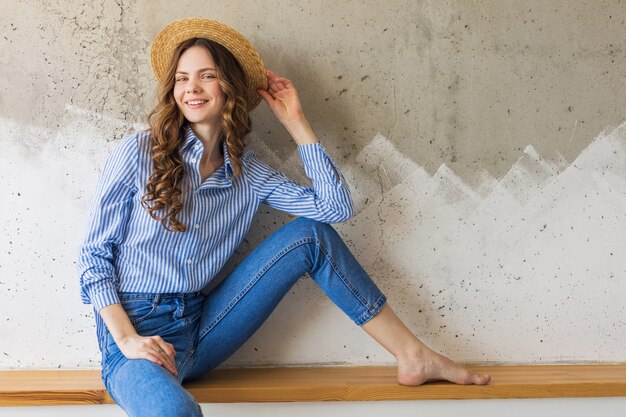 Young attractive stylish woman sitting at wall