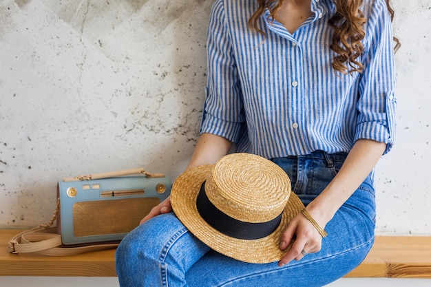 Free photo young attractive stylish woman sitting at wall