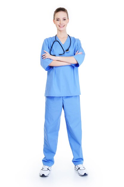파란색 유니폼을 입고 서있는 젊은 매력적인 성공적인 여성 외과 의사