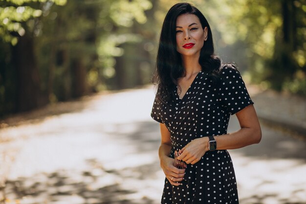 Young attractive woman in classy dress standing in forest