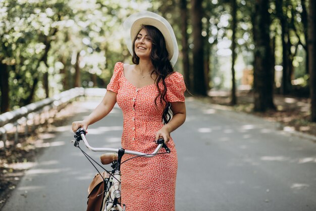 Молодая привлекательная женщина в платье, езда на велосипеде