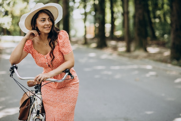 Young attractive woman in dress riding bicycle