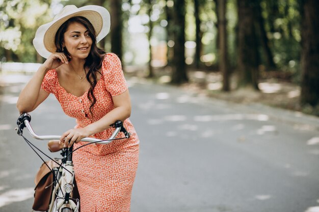 Young attractive woman in dress riding bicycle