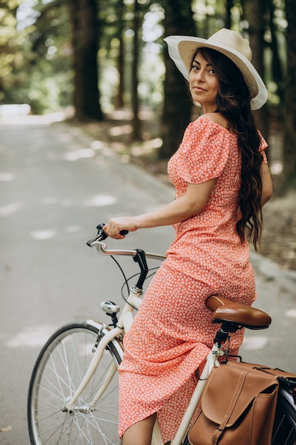 자전거를 타고 드레스에 젊은 매력적인 여자