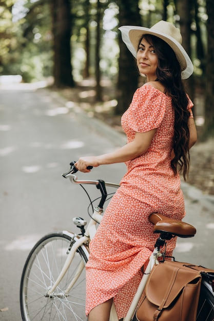 自転車に乗ってドレスの若い魅力的な女性