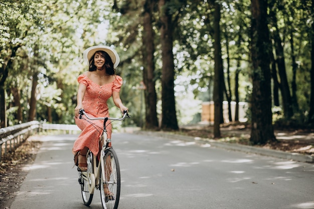 Young attractive woman in dress riding bicycle