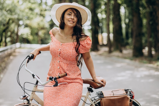 Young attractive woman in dress riding bicycle