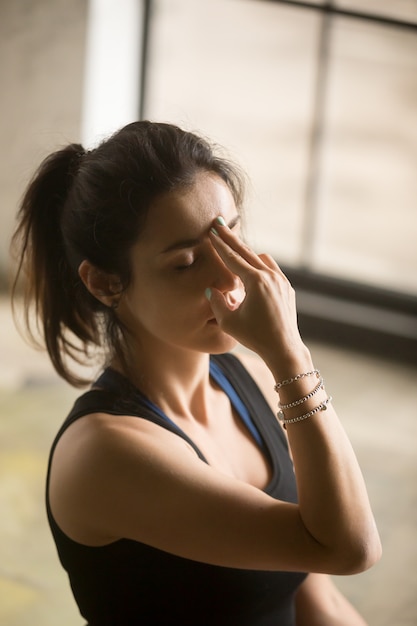 Young attractive woman making Alternate Nostril Breathing