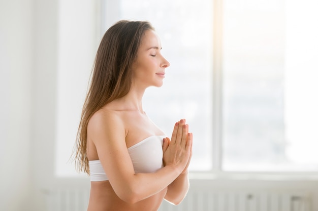 Young attractive woman making namsate gesture, white color backg