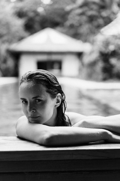 Foto gratuita giovane donna attraente nel ritratto in bianco e nero della piscina