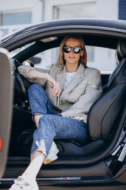 Free photo young attractive woman sitting in a car