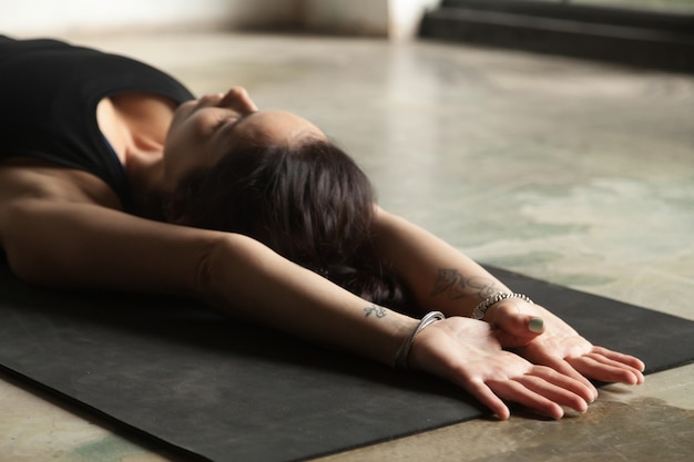 Young attractive woman stretching on the floor