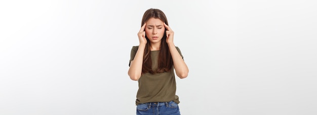 A young attractive woman suffering from illness or headache holding her head isolated on white