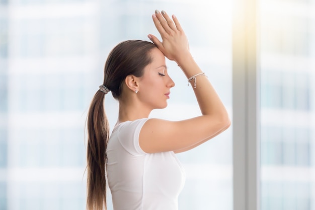 Foto gratuita giovane donna attraente nella posa di vajrasana, primo piano