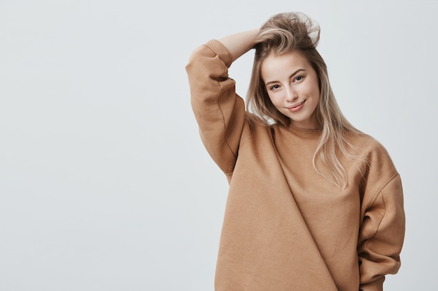Free photo young attractive woman wearing stylish long-sleeved sweatshirt and posing