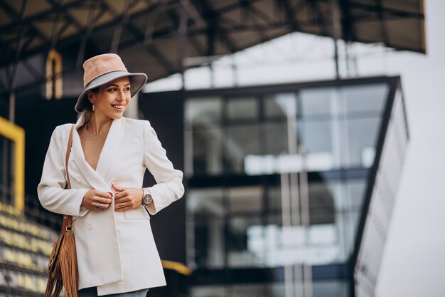 Young attractive woman in white jacket walking outdoors