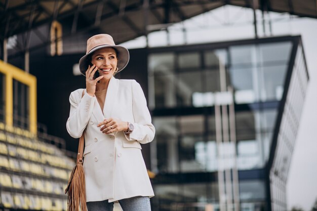 Young attractive woman in white jacket walking outdoors