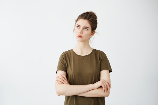 Young attractive woman with crossed arms thinking looking to distance.