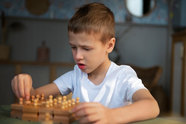 Free photo young autistic boy playing with toys at home