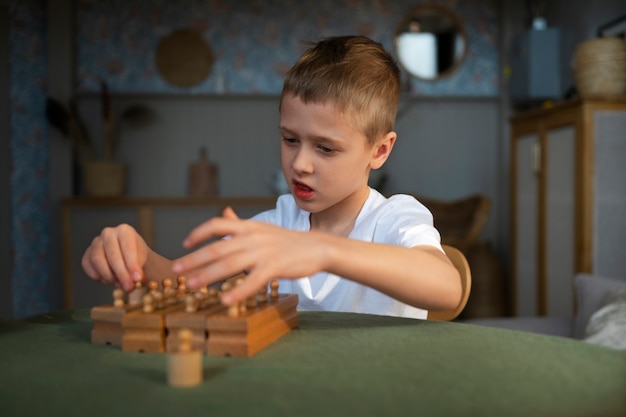 Free photo young autistic boy playing with toys at home