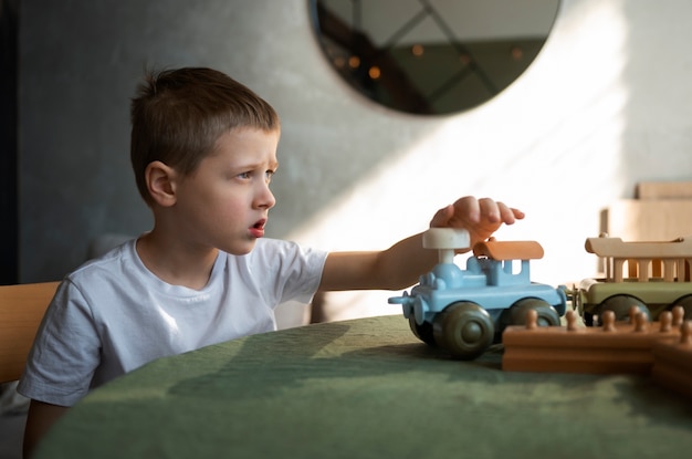 Foto gratuita giovane ragazzo autistico che gioca con i giocattoli a casa