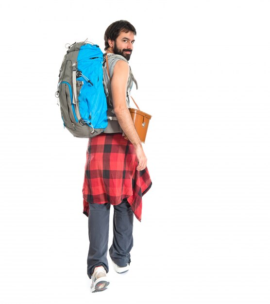 Young backpacker walking over white background