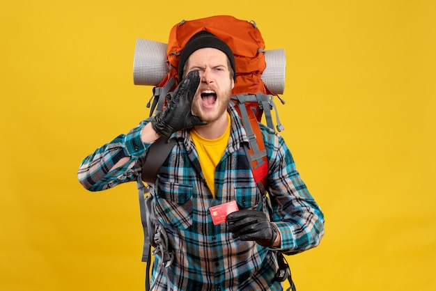 young backpacker with black hat holding credit card shouting