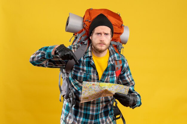 young backpacker with black hat pointing at map