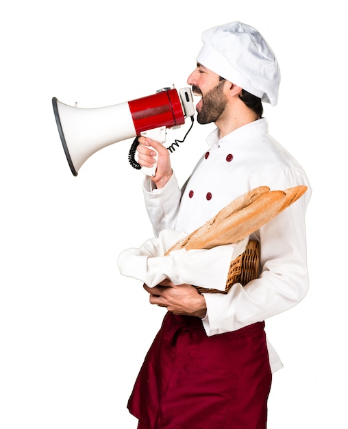 Бесплатное фото Молодой пекарь, держащий хлеб и кричащий по мегафону