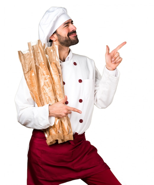 Young baker holding some bread and dancing