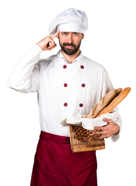 Young baker holding some bread and thinking