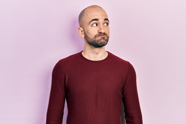 Free photo young bald man wearing casual clothes smiling looking to the side and staring away thinking.