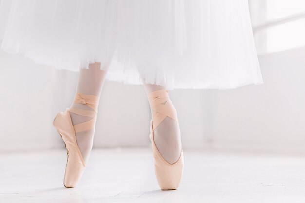 Молодая балерина, крупным планом на ногах и обувь, стоя в пуантах.